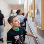 Endeavor Elementary School students look at the artwork in the tunnel that leads from Kirkhof Center to the Mary Idema Pew Library.